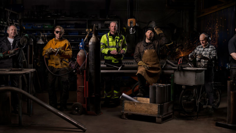Ljusmålad bild på personal i verkstaden. Foto: Kola Productions.