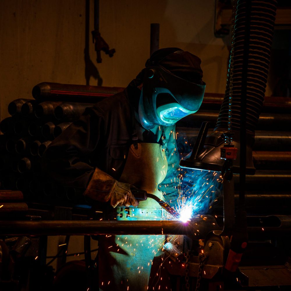 Svetsare svetsar på en belysningsstolpe. Foto: Kola Productions.