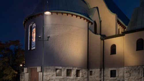 En belysningsstolpe och fasadbelysning i månskenet utanför Sundbybergs kyrka. Foton och redigering / ljusmålning av Kola Productions.
