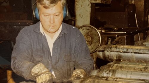 Stig Hökerud sitter och jobbar i verkstaden med en cigarett i munnen