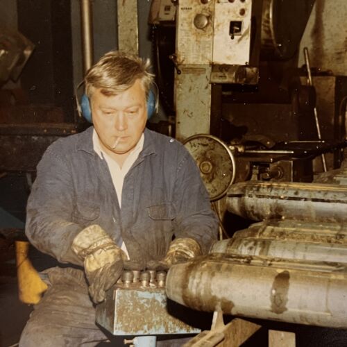 Stig Hökerud sitter och jobbar i verkstaden med en cigarett i munnen